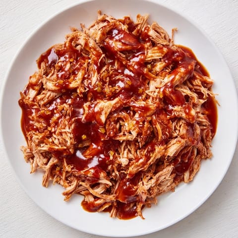 Pile this easy BBQ pulled chicken high on a plate, a comforting American classic.