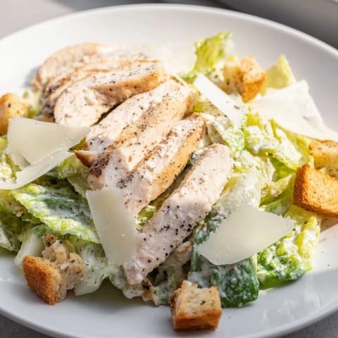 A vibrant close-up of a Chicken Caesar Salad boasting creamy dressing and savory chicken.