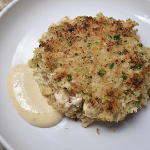 Delicious pan-fried crab cakes with visible chunks of sweet crab meat and parsley garnish.