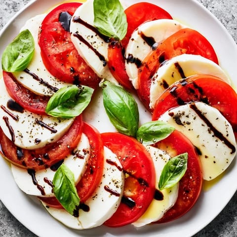 Slices of juicy tomato and fresh mozzarella create this vibrant Caprese salad.