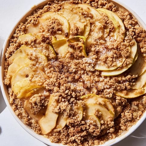 Golden-brown Apple Crumble with bubbling, spiced apples inside, ready to be served warm.
