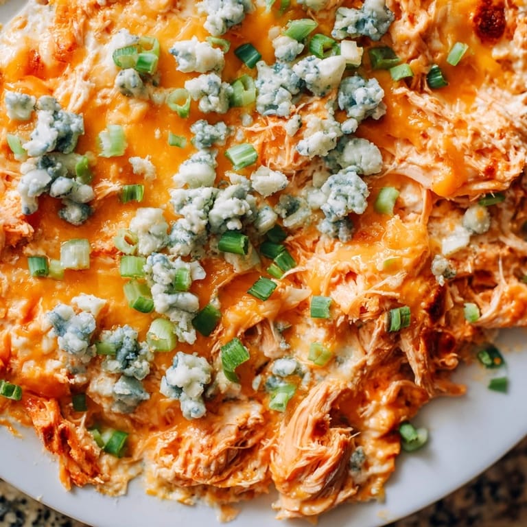 A close-up shot of creamy Buffalo Chicken Dip, loaded with melted cheese and ready to dip.