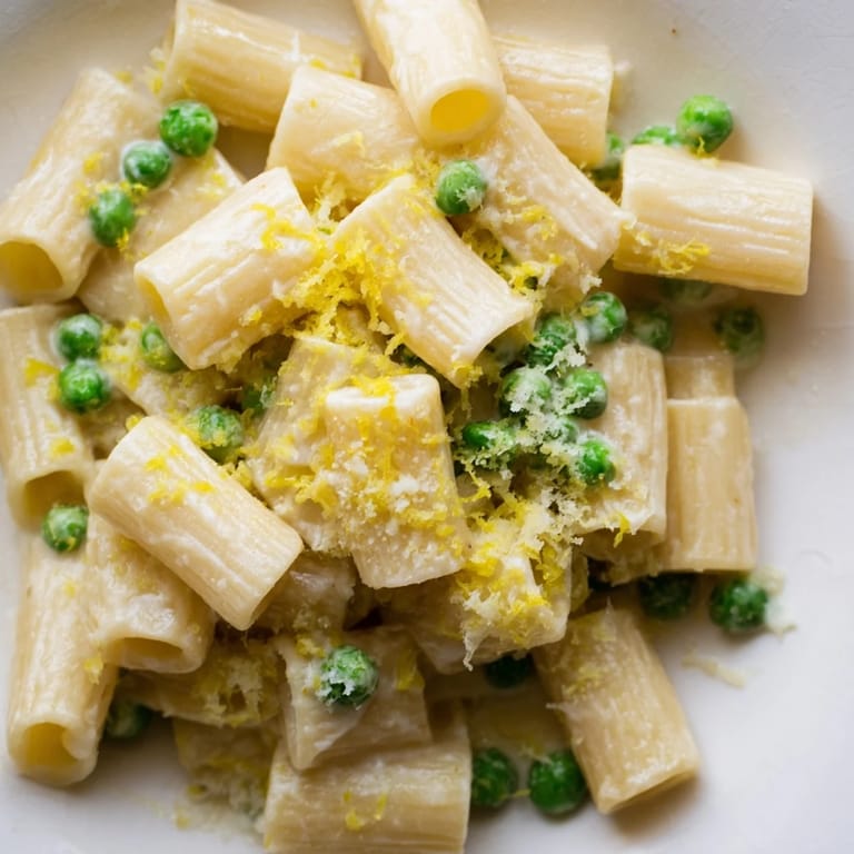 Steaming Pea & Lemon Ricotta Pasta is garnished with fresh basil and extra Parmesan, perfect for spring dinners.  