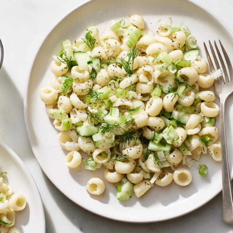 Chilled Cucumber Crunch Pasta Salad ready to serve, showcasing a creamy dressing, vibrant green onions, and everything bagel seasoning on tender pasta shells.