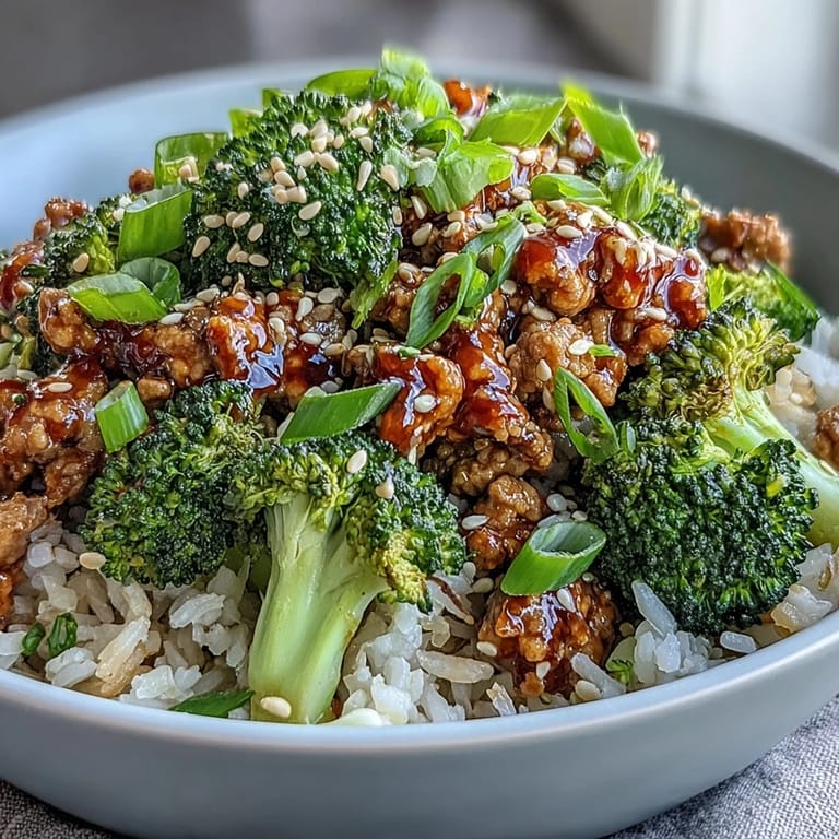 Overhead view of Sweet and Spicy Turkey Broccoli Bowls, highlighting vibrant green broccoli and sesame seeds over a honey-sriracha glazed turkey mixture served in a ceramic bowl.